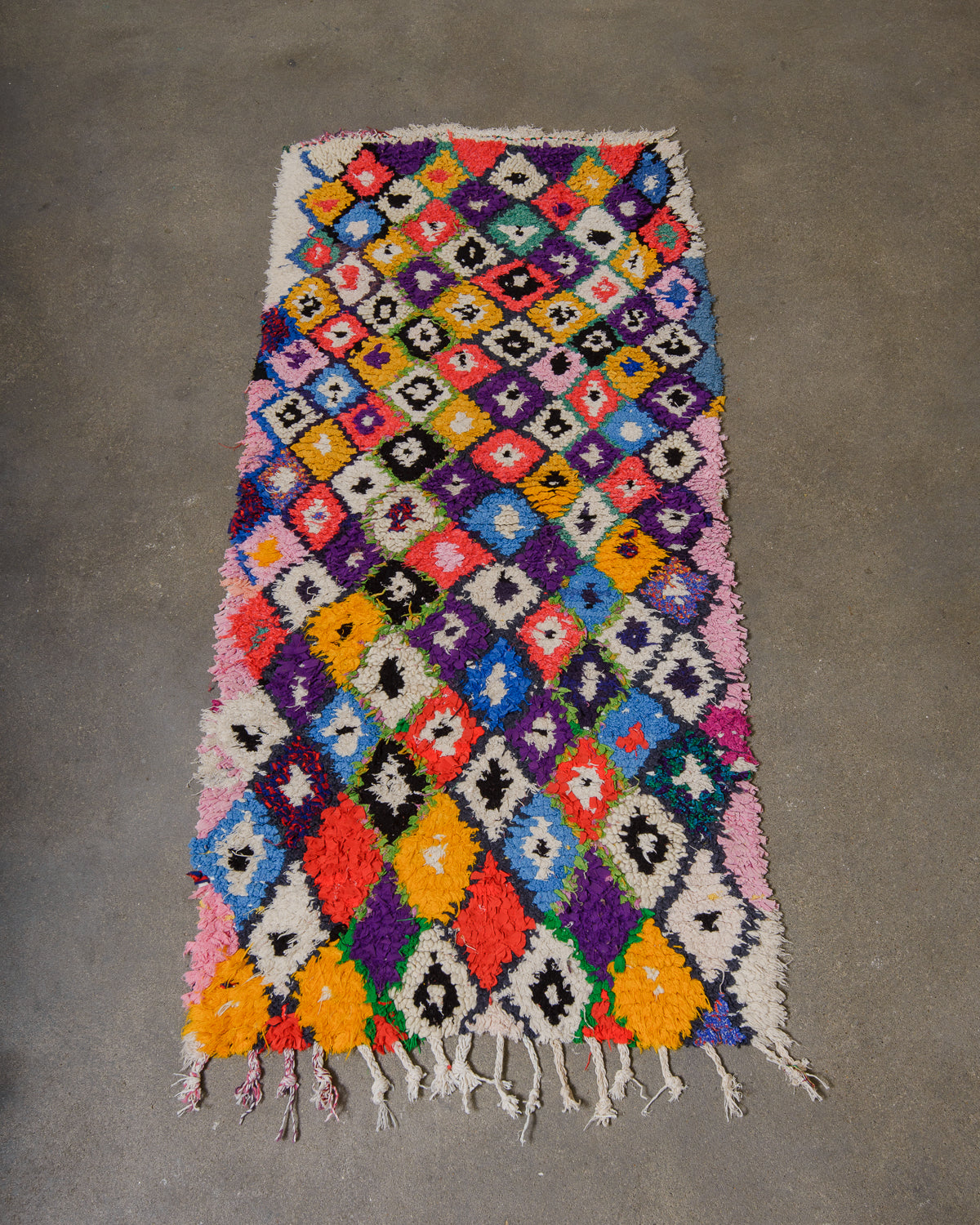 Colourful geometric patterned rug on a grey concrete floor